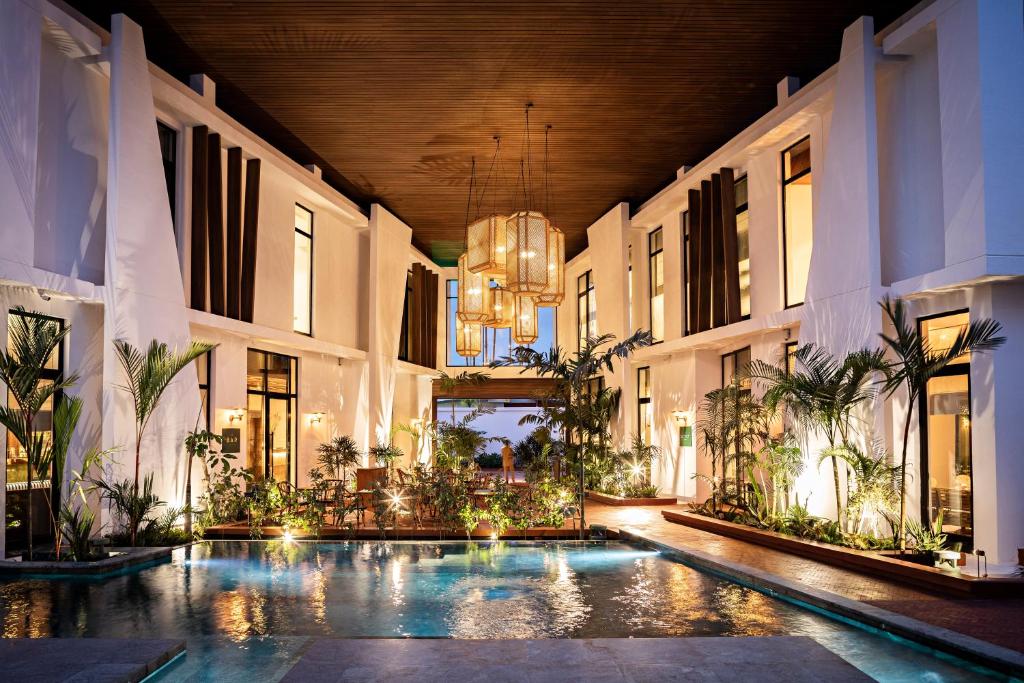 阿比让La Maison Palmier Abidjan, a Member of Design Hotels的一座带游泳池的室内庭院,位于一座建筑中