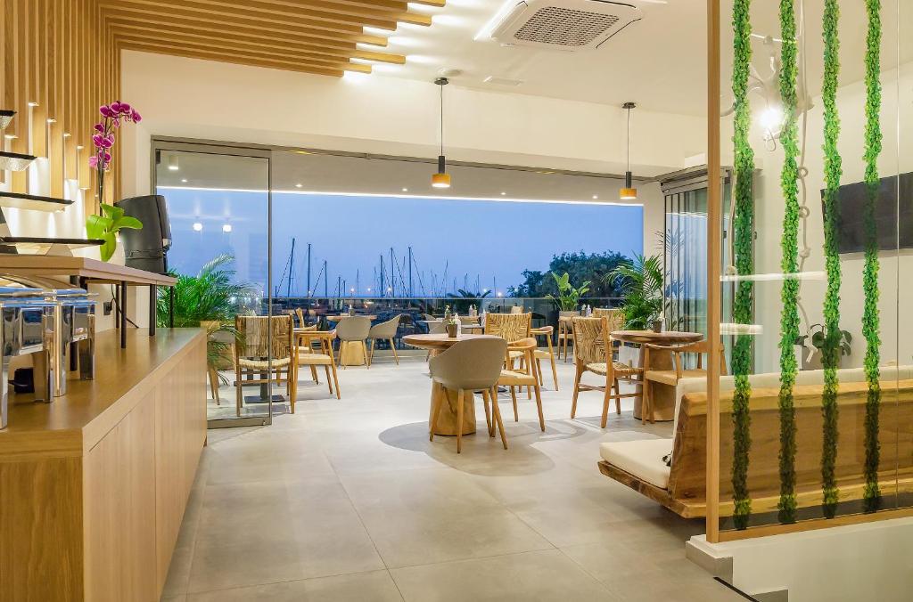 罗希姆诺SAVUS Boutique Hotel的一间带桌椅的海景餐厅