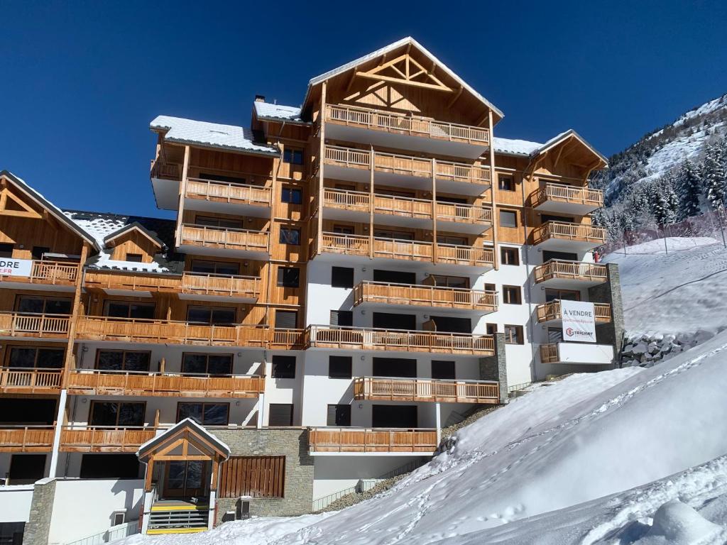 OzOz sur son 31 residence l oree des pistes的一座白雪覆盖的山顶上的建筑