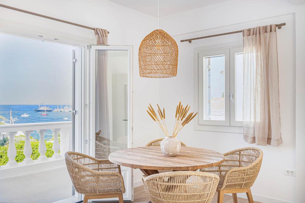 斯派赛斯Pearl House - Luxurious new beach villa in Spetses stunning view的一间带木桌和椅子的用餐室