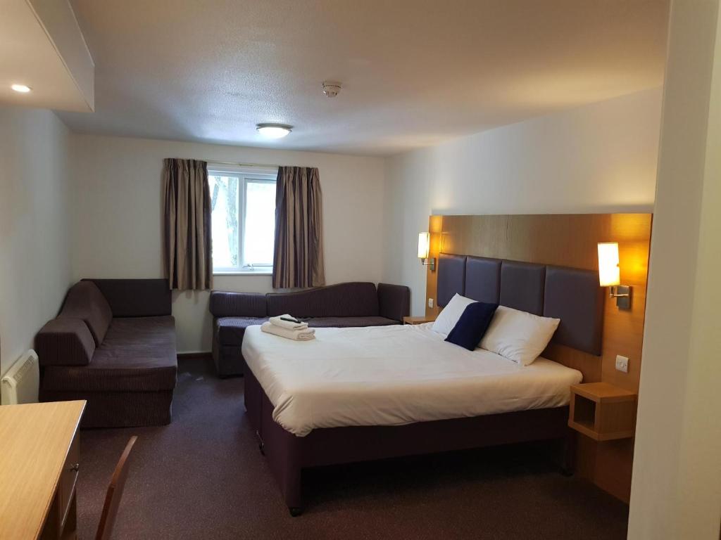 曼彻斯特V Lodge Manchester的酒店客房,配有床和沙发