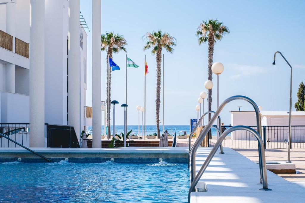 圣何塞Hotel Don Ignacio的棕榈树和海滩的游泳池