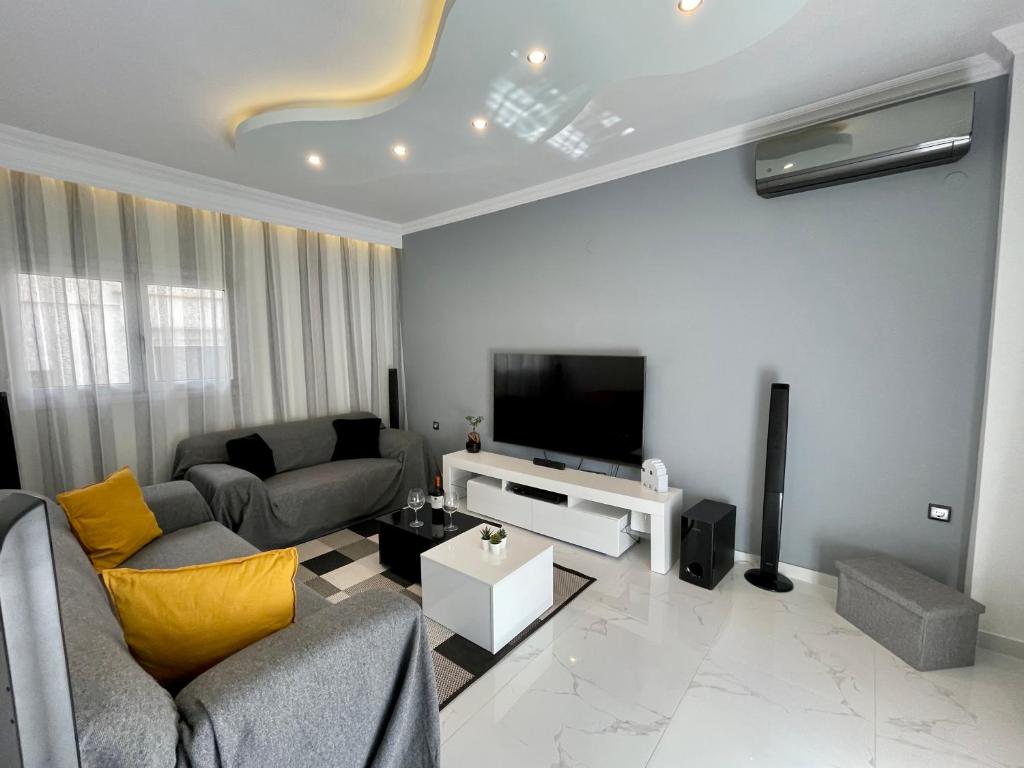 塞萨洛尼基Luxurious Modern Home in Kalamaria, Thessaloniki的带沙发和电视的客厅