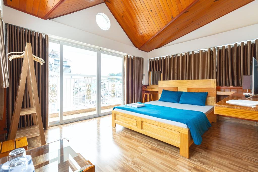 大叻吉雅范酒店的一间卧室设有一张床和一个大窗户