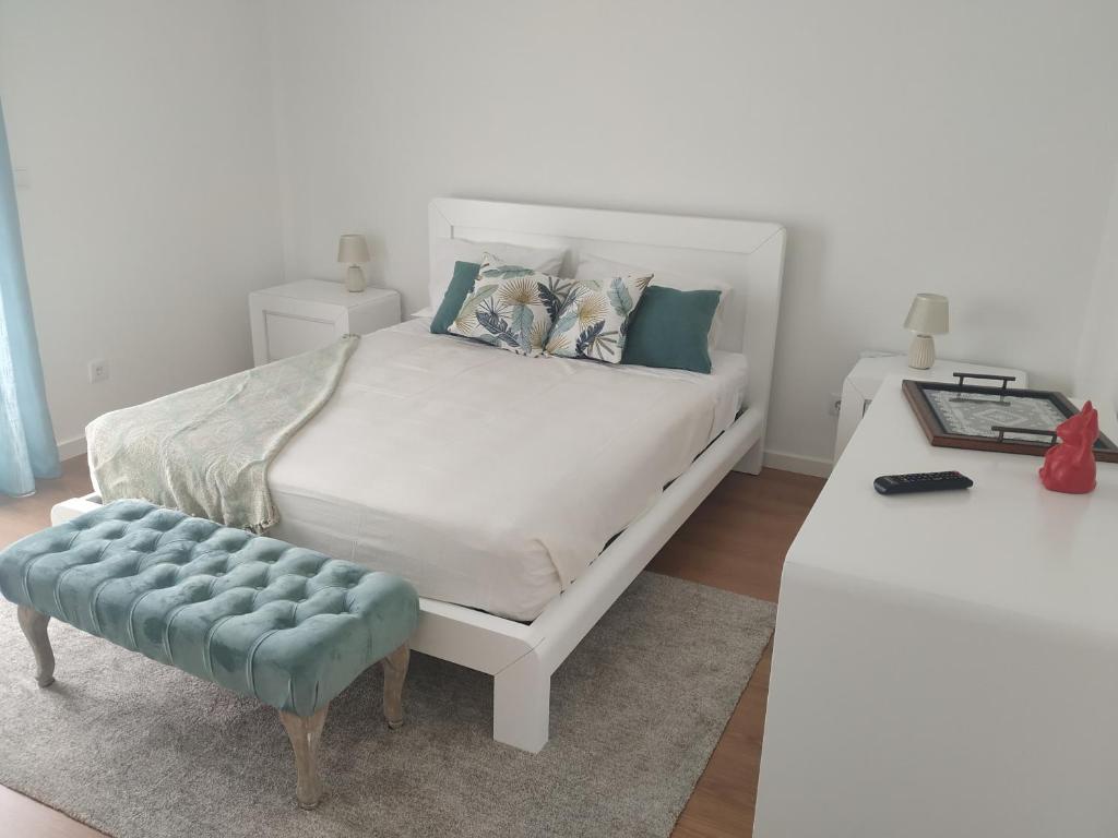 坎普自由鎮Brava的卧室配有白色的床和蓝色凳子