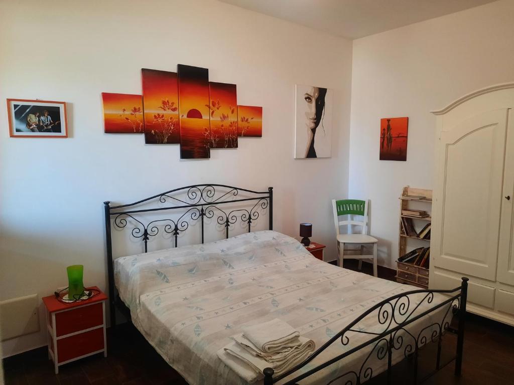 卡萨马塞拉Fata Morgana的一间卧室配有一张床,墙上挂着一些图片