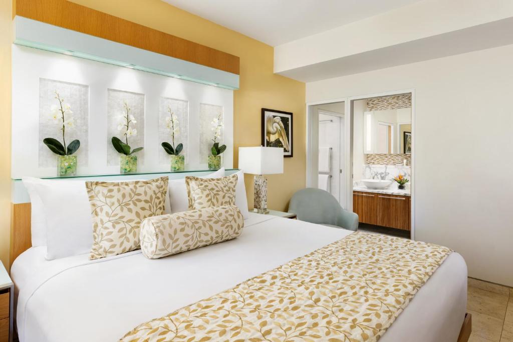 基韦斯特圣玛利亚套房度假村的一间带白色大床的卧室和一间浴室