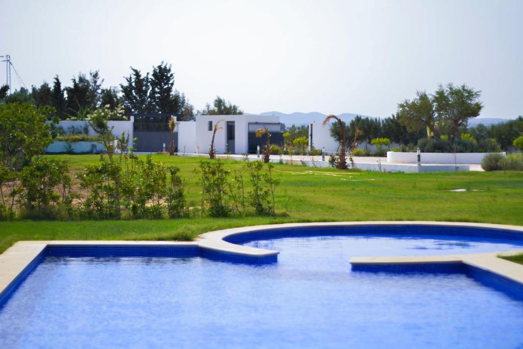 Hammamet SudMaison des Oliviers, Yasmine Hammamet, Bouficha的一座位于庭院内的游泳池,其建筑背景为: