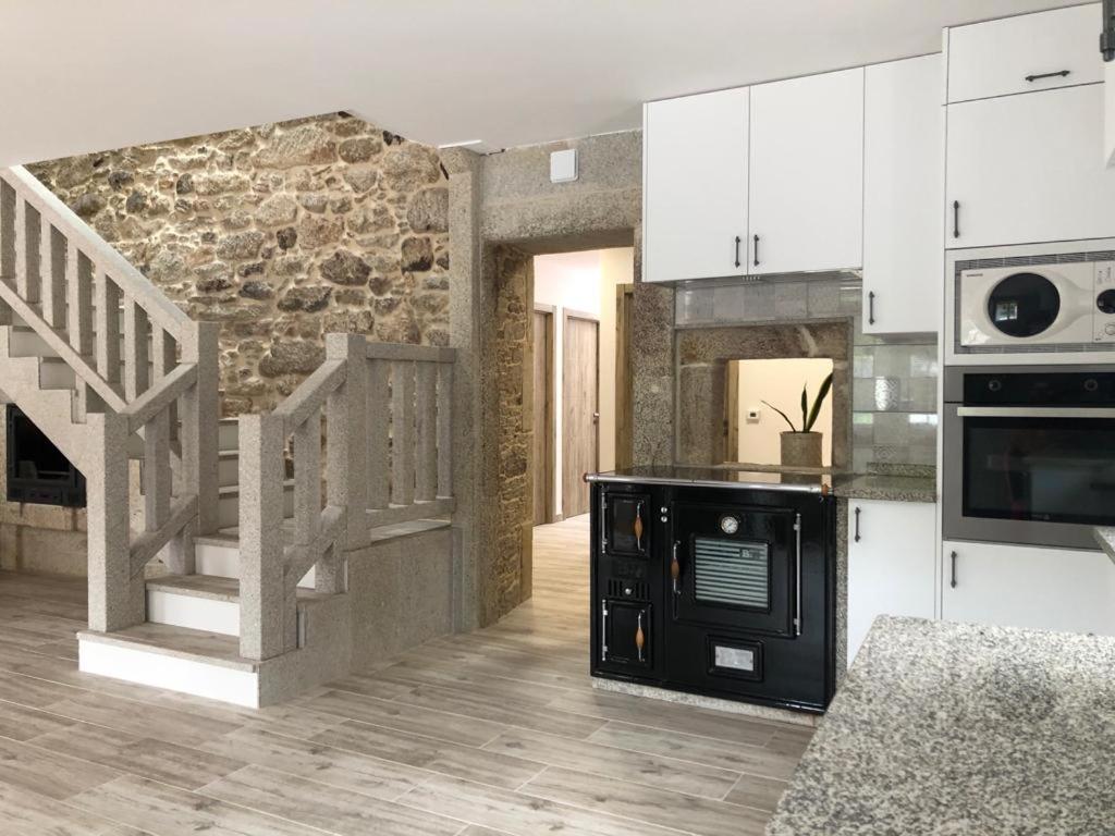 拉科鲁尼亚Casa A Braña的厨房配有白色橱柜和石墙