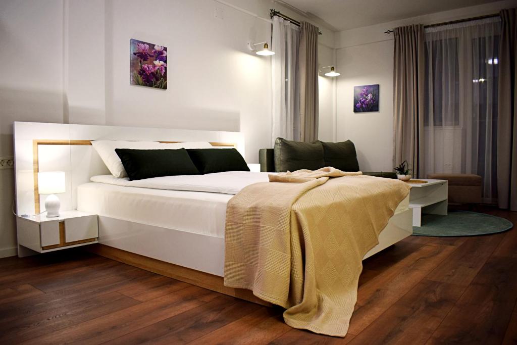 奥赫里德Iris Guesthouse的卧室配有一张白色的床,床上有毯子