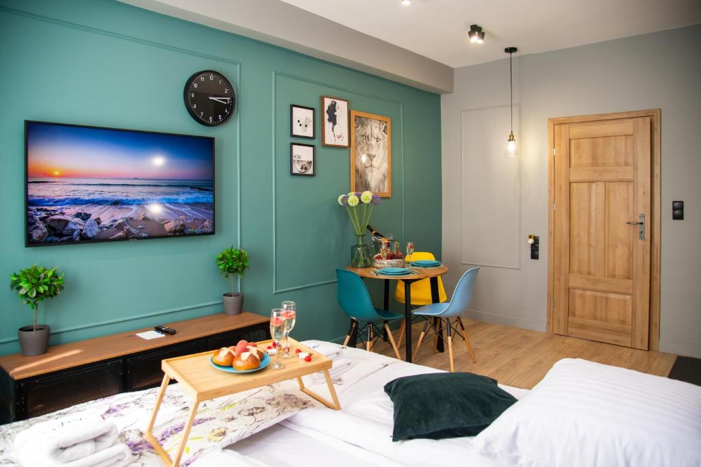 格但斯克Maya's Flats & Resorts 60 - Most Miłości的一间卧室设有蓝色的墙壁、一张床和一张桌子