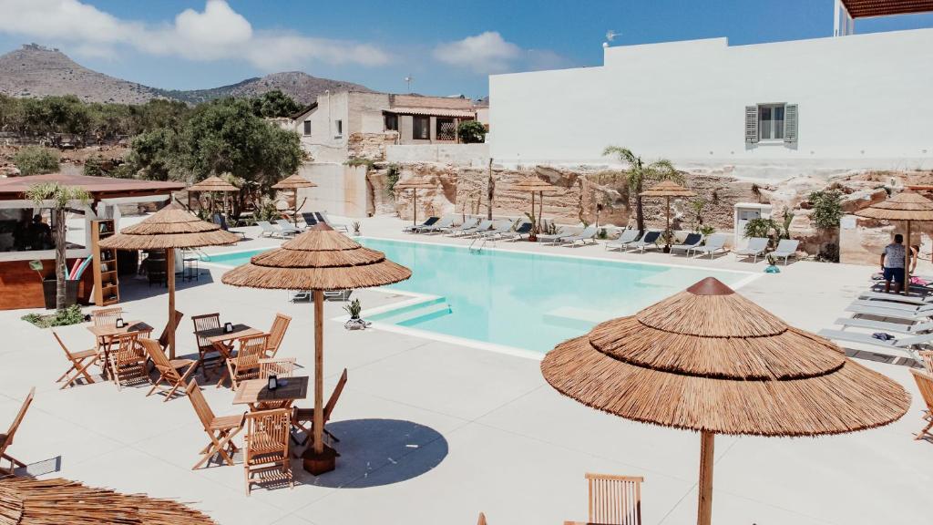 法维尼亚纳洛亚希艾尔伯格乡村酒店的一个带椅子和遮阳伞的游泳池的度假酒店