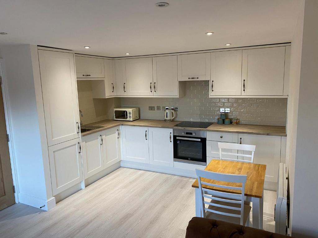 High HeatonNewly Refurbished Entire Apartment - South Gosforth, Newcastle的厨房配有白色橱柜和桌椅