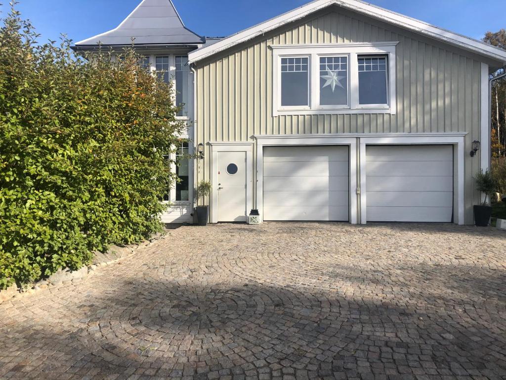SöråkerVilla Båthamnsgatan的两扇车库门和车道的房子