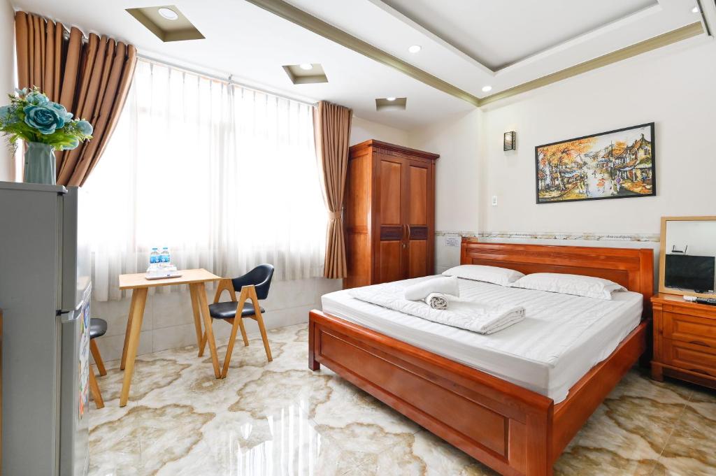 胡志明市Huyen House的一间卧室配有一张床、一张书桌和一台电视