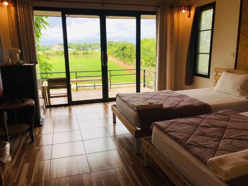 乌泰他尼府บ้านกลางเกาะ รีสอร์ท的客房设有两张床和一个美景阳台。
