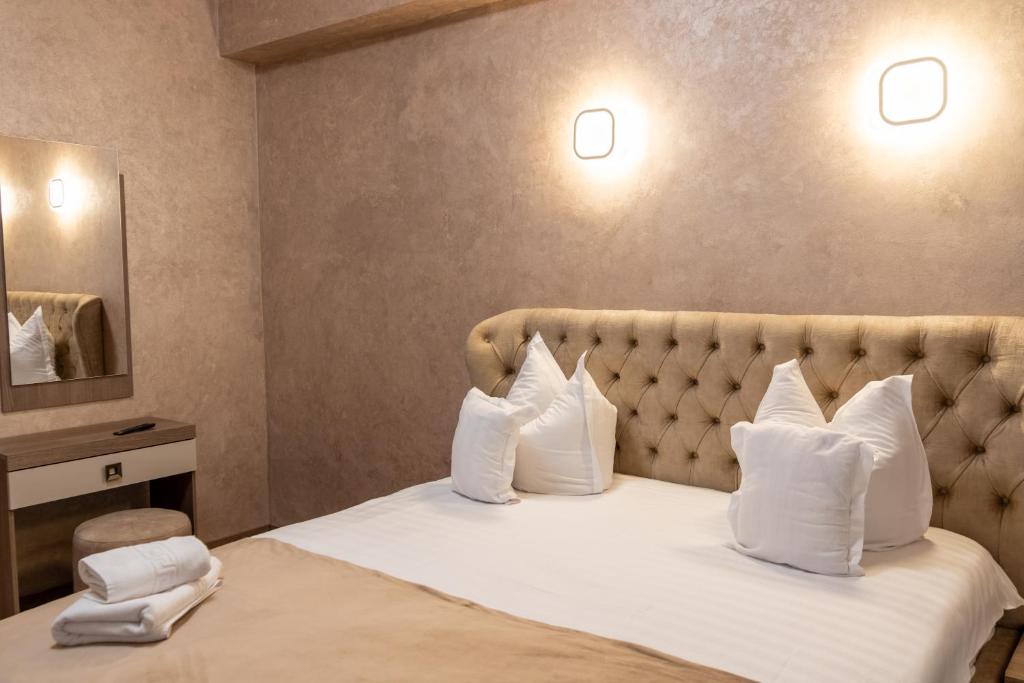 特尔古穆列什Pensiunea Europa的配有白色枕头的床的酒店客房