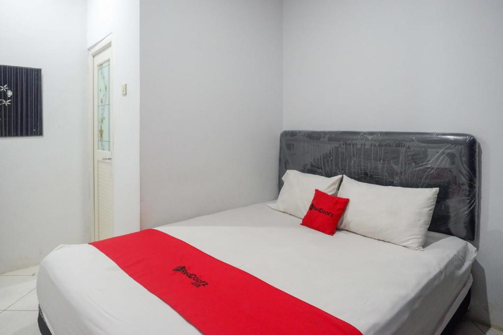 RempawahRedDoorz At Jalan Raya Baturaden的一张床上有两个红色枕头的房间