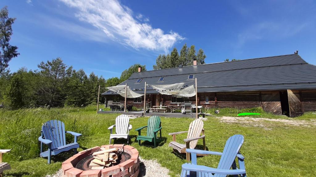 Raistiko Talu- Farmhouse, off-grid cabin and more的坐在火坑周围的椅子