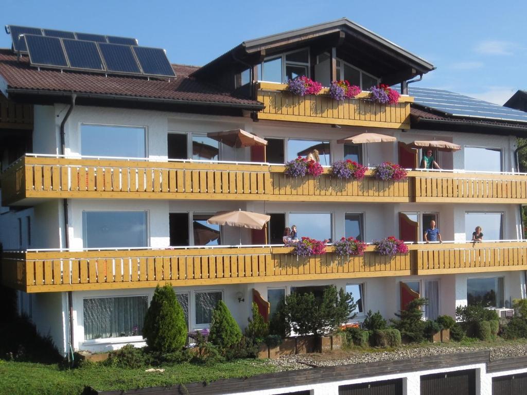 奥伊-米特尔贝格Haus Panorama的一座带鲜花和太阳能板阳台的建筑