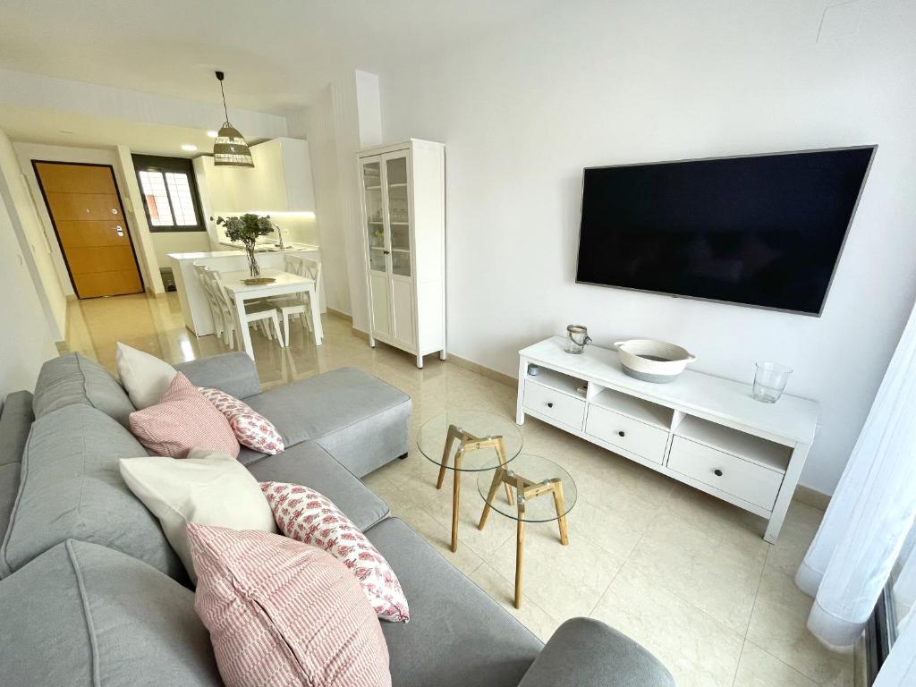 圣玛丽亚港El Arrecife - Apartamento a 2 minutos de la playa en El Puerto de Santamaría的客厅配有灰色沙发和平面电视