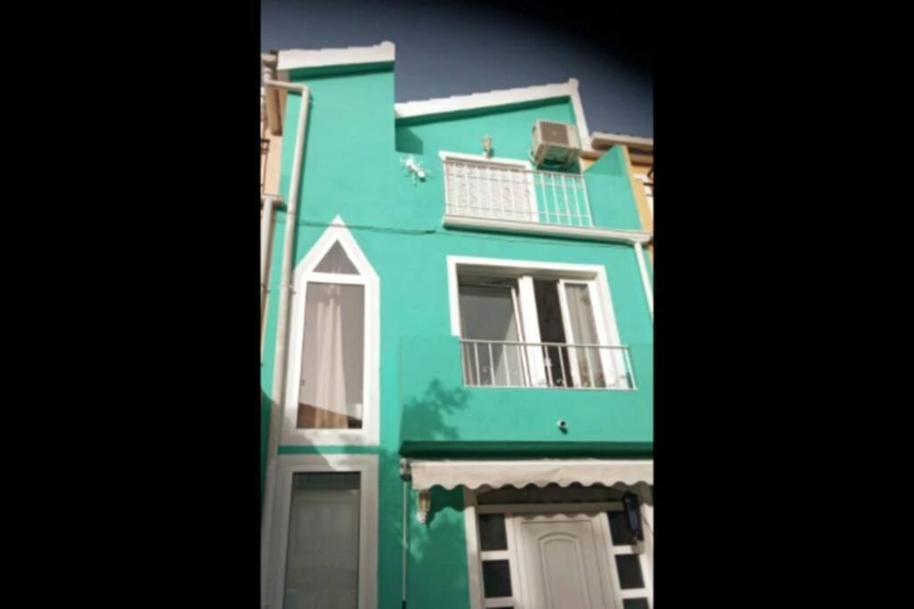 贝尼卡西姆Agradable adosado cerca de la playa的绿色建筑,设有两个阳台