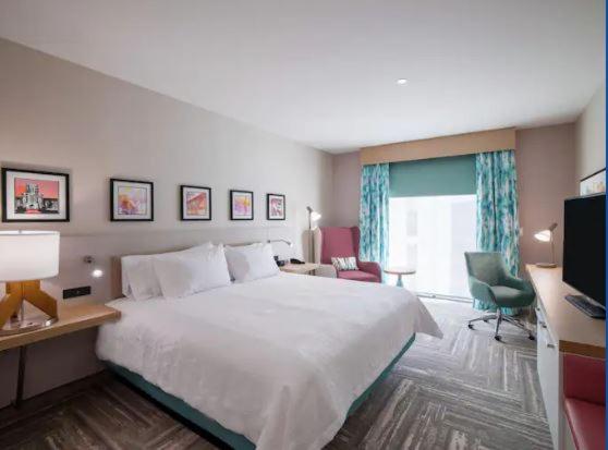 维塞利亚Hilton Garden Inn Visalia, Ca的酒店客房设有一张大床和一张书桌。