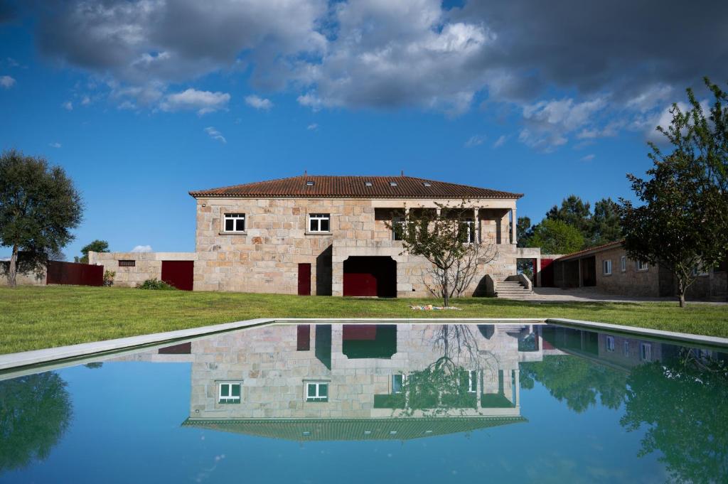 查韦斯Countryside Villa with Nature & Pool - 'Casa dos Vasconcelos'的一座古老的石头房子,前面设有一个游泳池