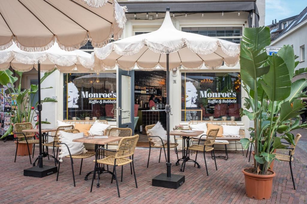 迪温特Monroe’s stay的一间餐厅,配有桌椅,位于伞下
