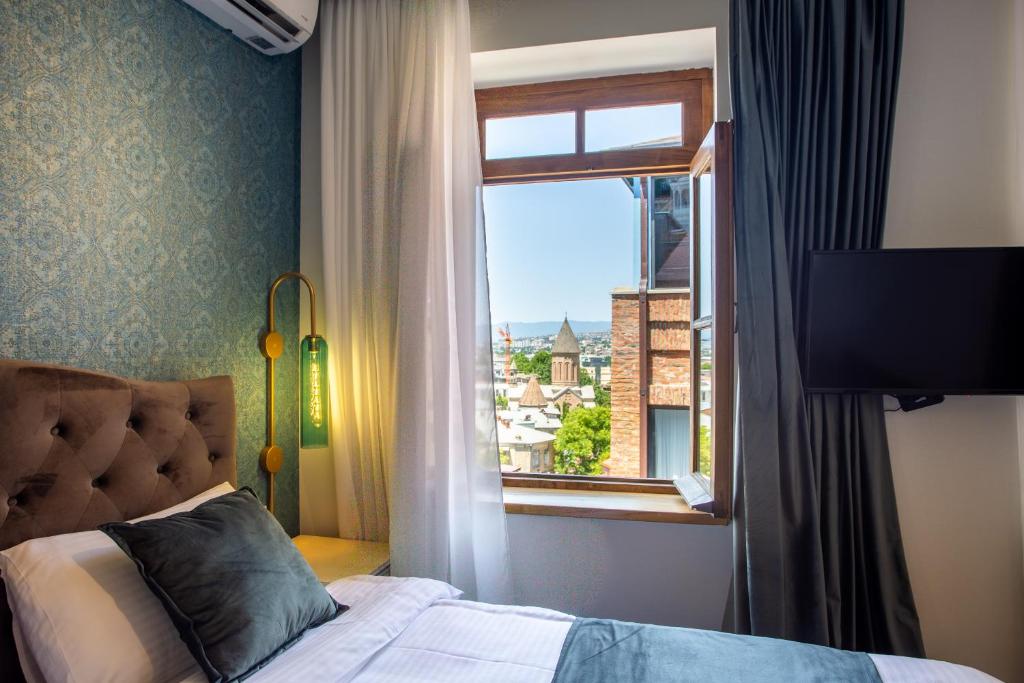 第比利斯Betlemi Hotel的一间卧室设有一张床和一个美景窗户。