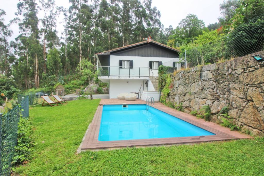 维埃拉·多米尼奥Casa da Quintã - Gerês, Vieira do Minho的庭院中带游泳池的房子