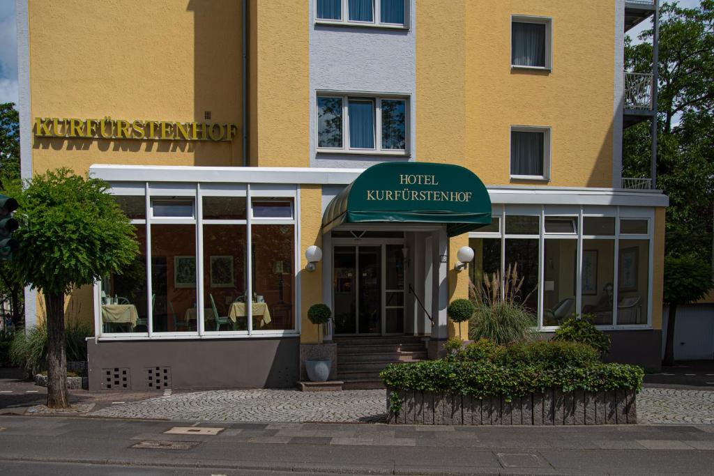 波恩库弗斯藤霍夫酒店的黄色建筑,带有读取酒店神经刀的标志