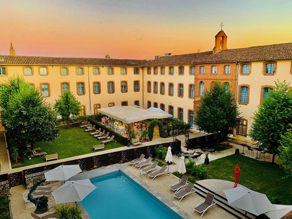 蒙托邦Abbaye des Capucins Spa & Resort的一座带游泳池和大楼的酒店