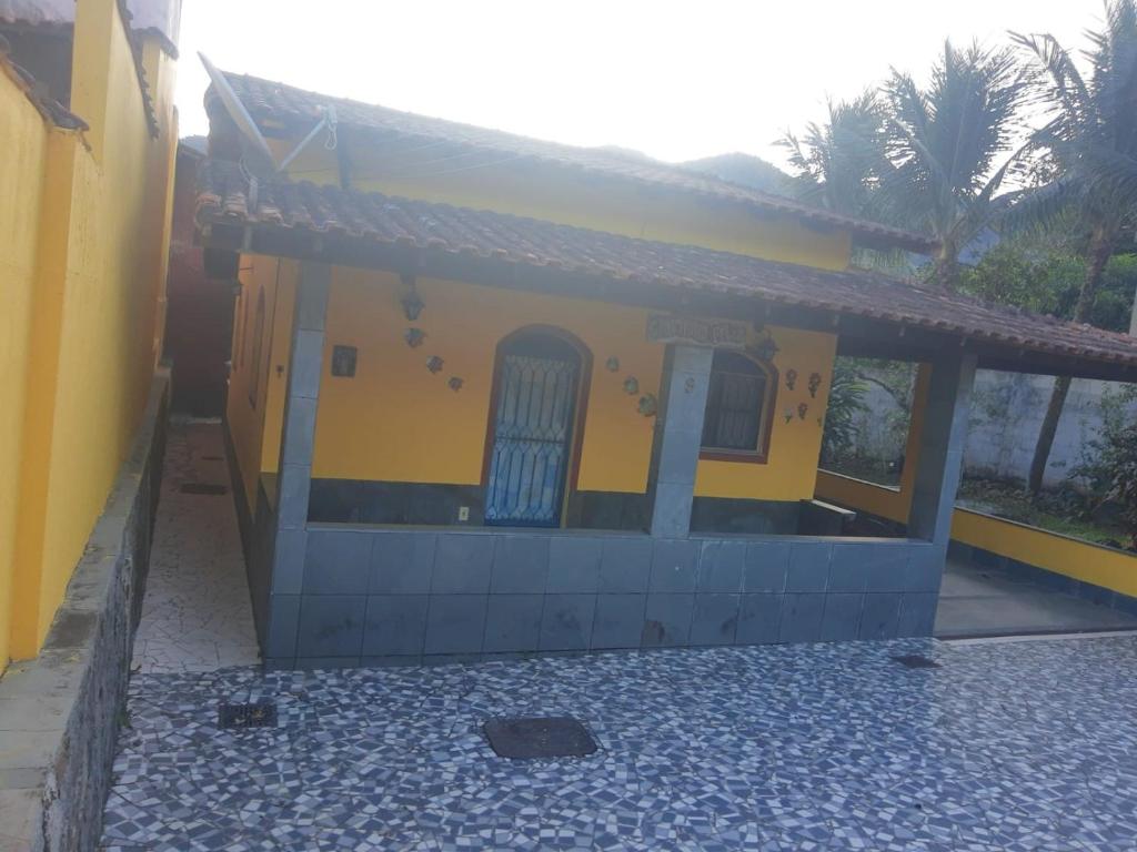 曼加拉蒂巴CASA COMPLETA-CONCEIÇÃO DE JACAREÍ -COSTA VERDE的黄色和蓝色的房子,设有门廊