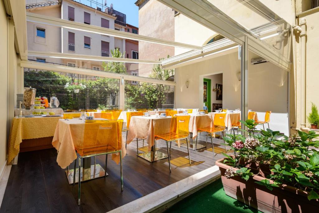 罗马圣莫里茨酒店的阳台餐厅设有黄色桌椅