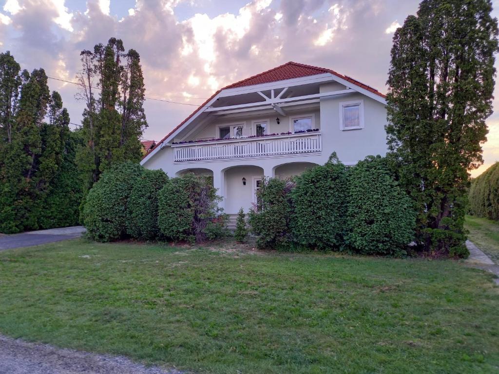 赫维兹Hévízi fecskefészek的带阳台和灌木丛的白色房屋
