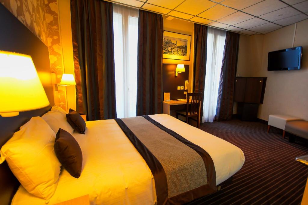 巴黎三车站酒店的一间酒店客房,房内配有一张大床