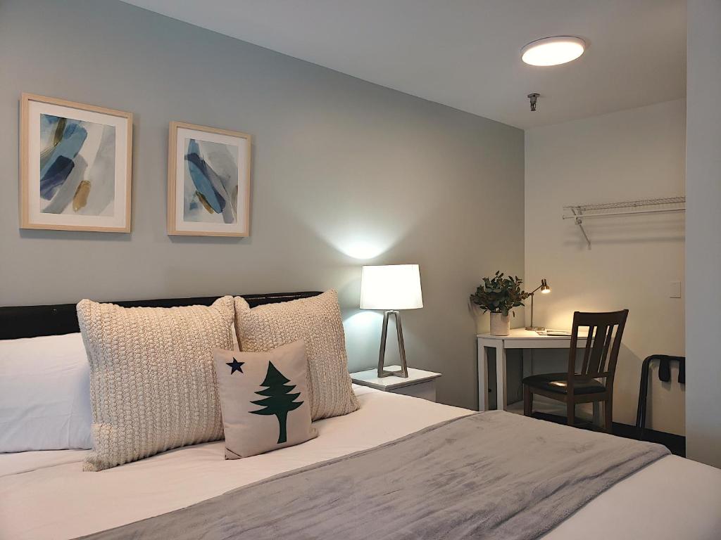 巴港Main Street Motel的一间卧室，里面有一张床和一张桌子和椅子