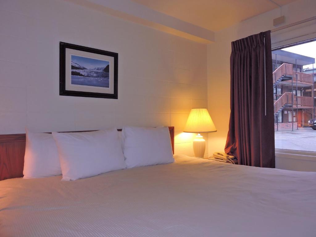 朱诺The Driftwood Lodge的一间卧室设有一张大床和一个窗户。
