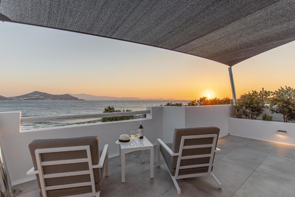 纳克索乔拉加里尼酒店的阳台配有桌椅,享有海景。