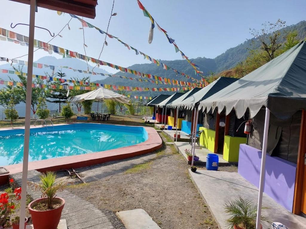 穆索里Mussoorie Camp Resort的一个带游泳池和一些帐篷的度假村