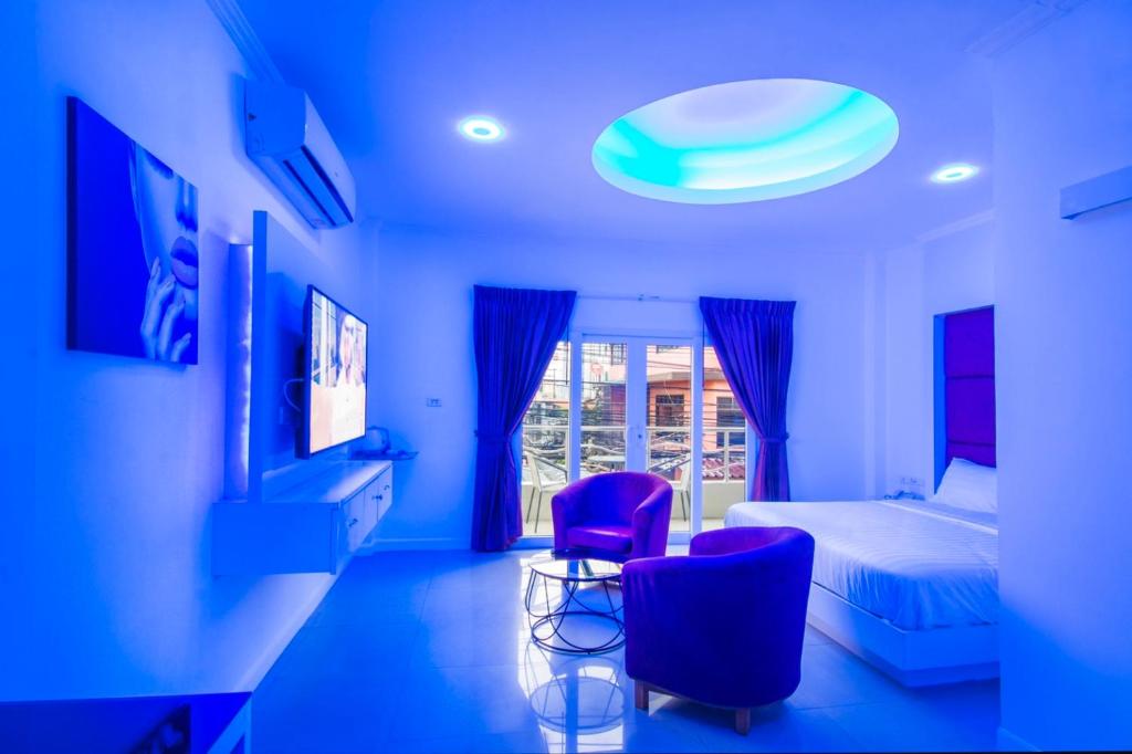 芭堤雅市中心titanic residence的蓝色客房 - 带一张床和两把紫色椅子