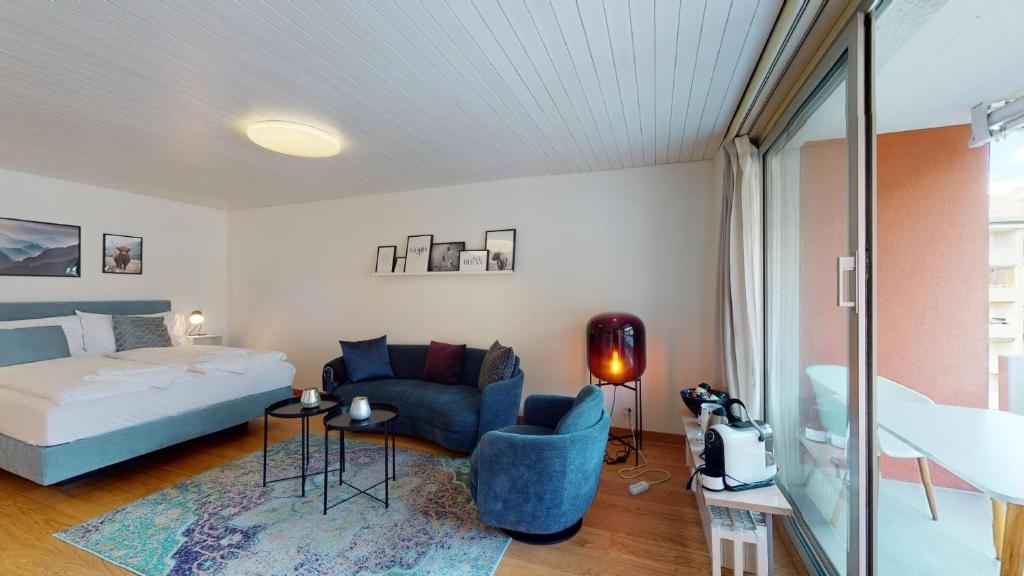 圣莫里茨Abitaziun Skyline 414 - St Moritz "LOGA ELEGANCE APARTMENT"的一间卧室配有一张床和一张蓝色椅子