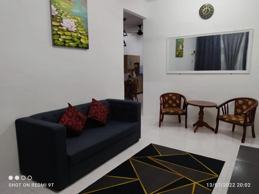 日得拉Adempuri homestay的客厅配有蓝色的沙发和两把椅子