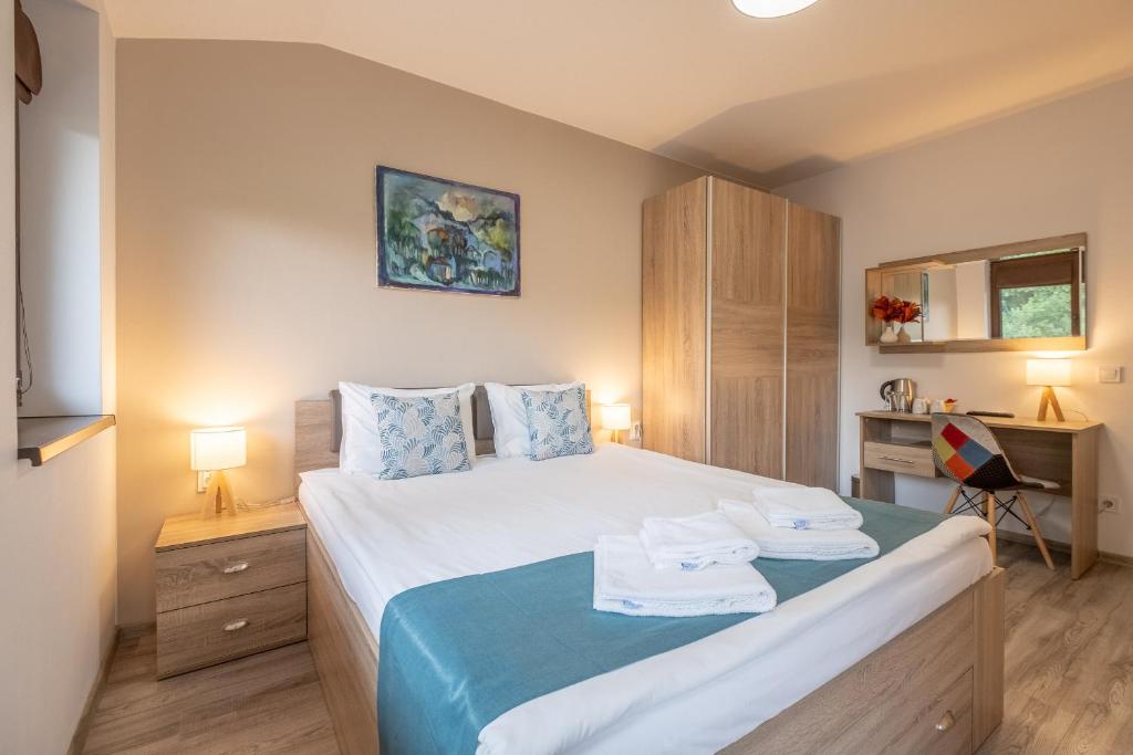 大特尔诺沃Tarnovgrad Apartments - Free parking的一间卧室配有一张床和一张带两条毛巾的书桌