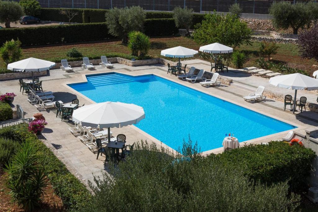 阿尔贝罗贝洛拉玛朋杜拉酒店的享有带椅子和遮阳伞的游泳池的上方景色