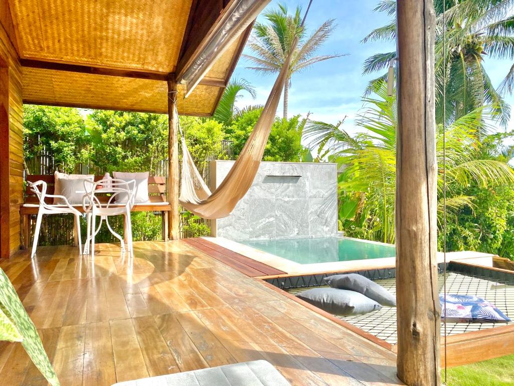 新孔Nibbana Bungalows的一个带吊床的庭院和一个游泳池