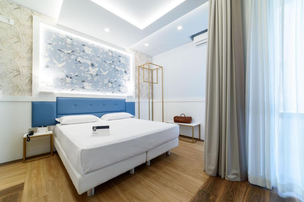 巴蒂帕利亚皇宫酒店的卧室配有白色的床和墙上的绘画作品