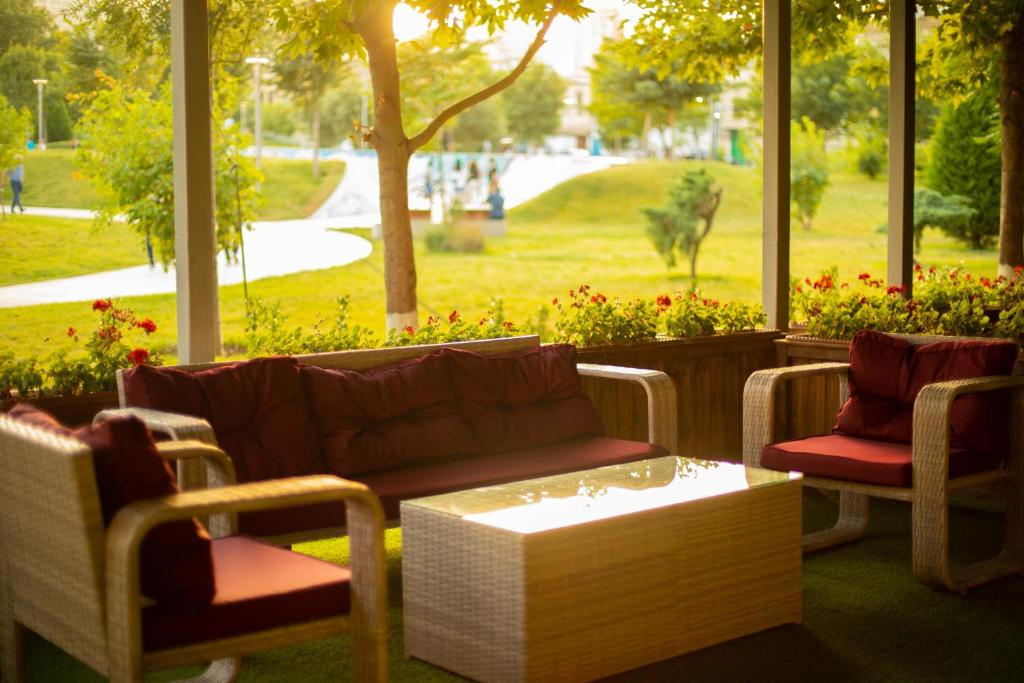 巴库Grand Hotel Baku Central Park的门廊配有沙发、两把椅子和一张桌子