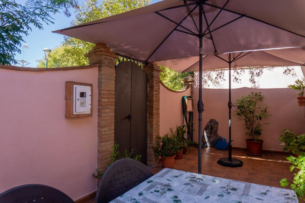 马拉加Beautiful Málaga House - Holidays的一个带桌子和遮阳伞的庭院